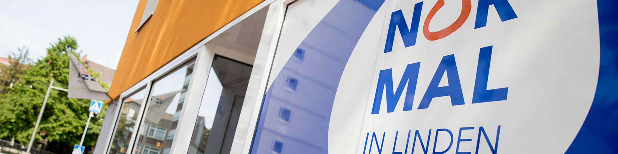 NiL - Normal in Linden Bildbeschreibung Headerbild: Auf dem Bild ist der Eingang zum NiL und das NiL-Logo zu sehen.